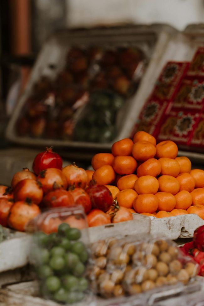 A colorful array of fresh fruits at a market stall showcasing vibrant oranges and assorted produce.