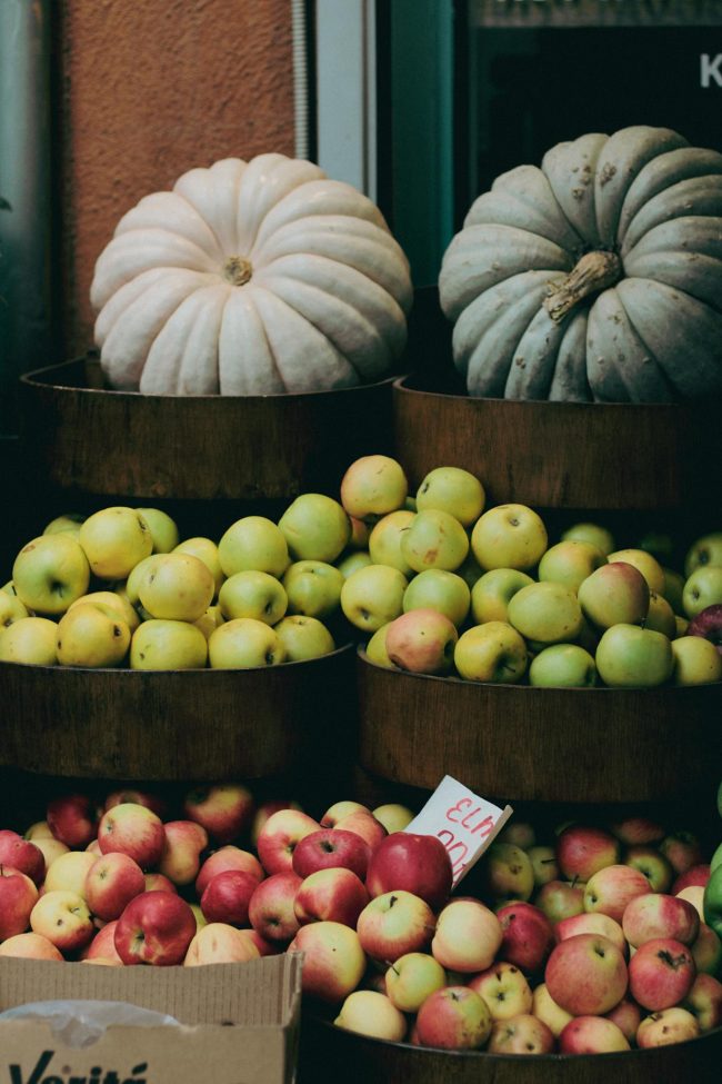 Assorted apples and pumpkins displayed at a local market, showcasing vibrant seasonal produce.