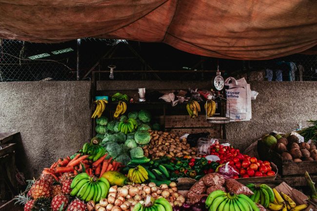 Colorful array of fruits and vegetables at a market stall with rustic ambiance.