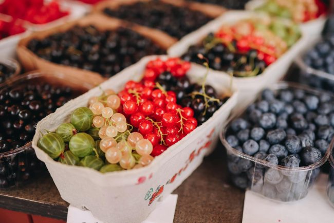 Vibrant selection of various fresh berries in baskets at a local market.